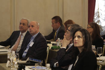 Andreas Dracopoulos, the co-president of the Stavros Niarchos Foundation, and other people sit in conference tables